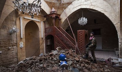 Un soldado rebelde en una mezquita del casco hist&oacute;rico de Alepo, da&ntilde;ada por la artiller&iacute;a.