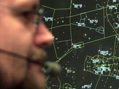 Un controlador aéreo en su puesto de trabajo frente a una pantalla de organización del tráfico.