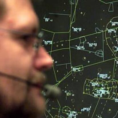 Un controlador aéreo en su puesto de trabajo frente a una pantalla de organización del tráfico.