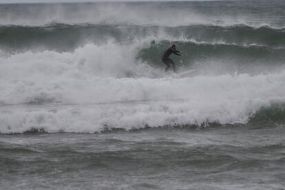 Un hombre practica surf, este domingo, en la localidad cántabra de Suances. 