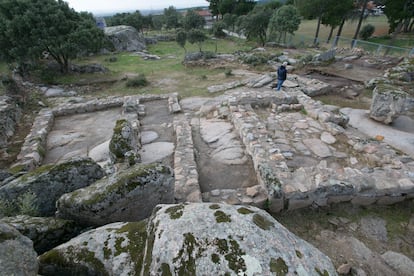 Muros del complejo religioso del yacimiento de Hoyo de Manzanares y,  al fondo, los restos de las viviendas que se extienden ladera abajo.