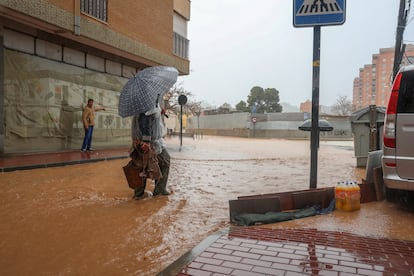 Un hombre con botas y paraguas en el San Cristóbal de Lorca (Murcia), este jueves.
