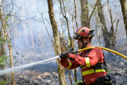 Un bombero trabajaba el domingo en la extinción de un incendio en Las Regueras, cerca de Oviedo.