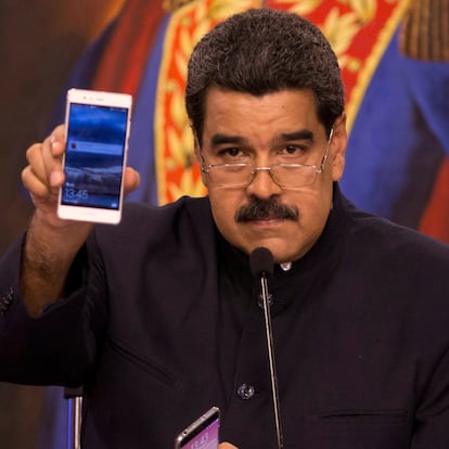 Venezuela's President Nicolas Maduro shows a solidarity message he received on his mobile phone, during a news conference in Caracas, Venezuela, Tuesday, Aug. 22, 2017. Immigration authorities in Colombia announced that Venezuela's ousted chief prosecutor Luisa Ortega Diaz is on her way to Brazil. Ortega said that Maduro removed her in order to stop a probe linking him and his inner circle to nearly $100 million in bribes from Brazilian construction company Odebrecht. (AP Photo/Ariana Cubillos)