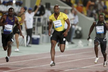 Powell, en el centro, durante la carrera de 100m en Doha.