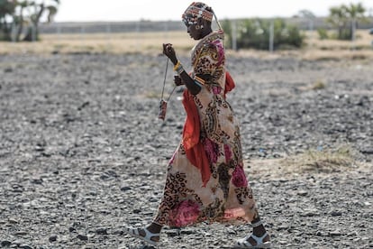 Una mujer vestida con traje tradicional y sandalias camina por los alrededores del festival, cerca del lago Turkana. Se trata de un entorno árido y con sequías periódicas agravadas por los efectos del calentamiento global.