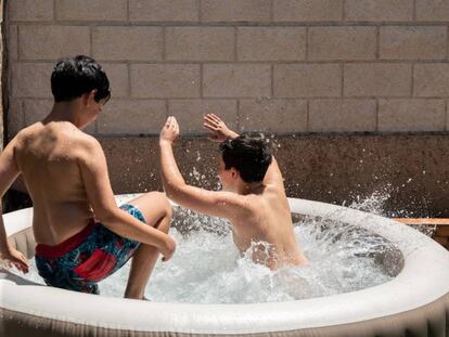 Niños jugando en una piscina hinchable. 