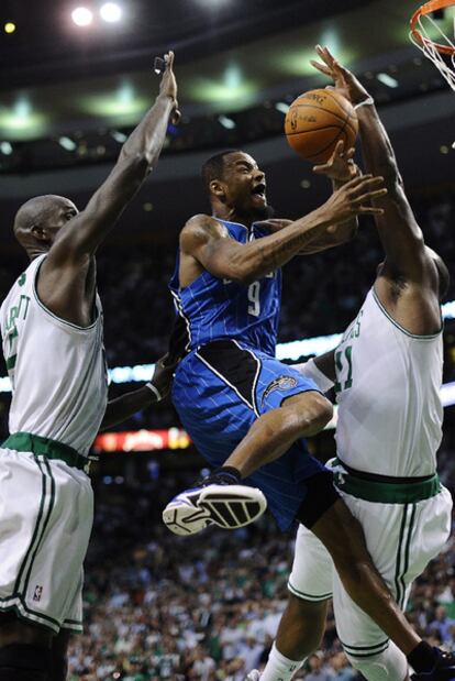 El jugador de los Magic Rashhard Lewis intenta un lanzamiento entre dos jugadores de los Celtics de Boston durante un partido de la final de la Conferencia Este de la NBA.