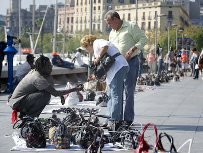 Una pareja compra en el 'top manta'.