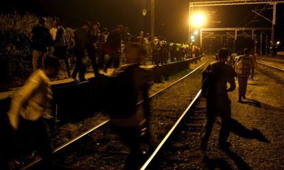 Migrants walk along the railway tracks towards the border with Serbia, near northern Macedonian village of Tabanovci late Monday, July 20, 2015. Macedonia has become a major transit route for thousands of Middle Eastern, Asian and African refugees and migrants who cross over from Greece and then continue into Serbia on the way to more prosperous European countries. (AP Photo/Boris Grdanoski)