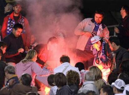 Aficionados del Espanyol intentan apagar las bengalas lanzadas por los seguidores del Barcelona