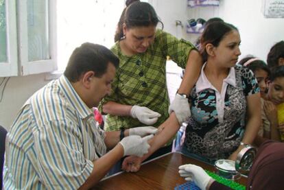 Una joven se somete a una extracción de sangre en un centro sanitario. En Egipto, el país donde la hepatitis C se propaga con más rapidez, la falta de controles permite a los recolectores de basura convertir jeringuillas utilizadas en objetos de plástico de uso cotidiano como cuencos o 'shishas'.