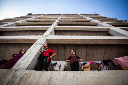 Una familia observa el trabajo del equipo de Acción contra el hambre desde su vivienda provisional.