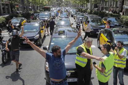 Un taxista con los brazos en alto delante de la larga cola de taxis que ha bloqueado el centro de la ciudad.