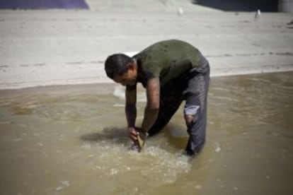 Otro deportado se lava en el río.