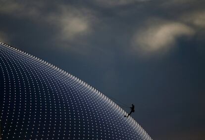 Una persona escala la Bolshoi Dome, una de las sedes de hockey sobre hielo, antes de una ceremonia de entrega de medallas de los Juegos Olímpicos de Invierno de Sochi.