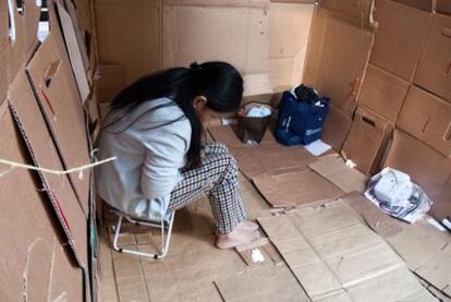 Una empleada doméstica se atrinchera tras unos cartones para pasar su día libre en Hong Kong.