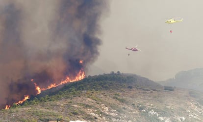 Helicópteros sobrevuelan la zona del incendio junto a la urbanización Cumbres del Sol, cerca de Benitatxell.