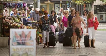 Varios turistas, con sus maletas, por una de las calles de Torremolinos.