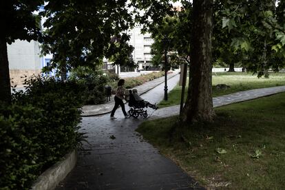 Una mujer empuja a una anciana en silla de ruedas en un parque en Grado, Asturias.