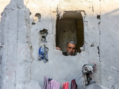 Un gazatí observa desde su casa las labores de rescate en un edificio adyacente derruido tras un bombardeo israelí.