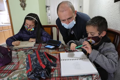 Un padre ayuda a sus hijos a estudiar en casa, durante la pandemia de la covid-19, en Bogotá (Colombia), el 13 de junio de 2020. 