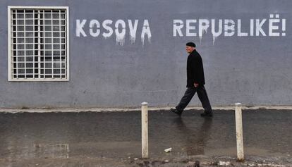 Un alban&eacute;s pasa ante un cartel en el que se lee &ldquo;Rep&uacute;blica de Kosovo&rdquo;, en Pr&iacute;stina.