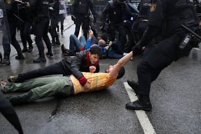 Riot police remove demonstrators outside a polling station for the banned independence referendum in Barcelona.