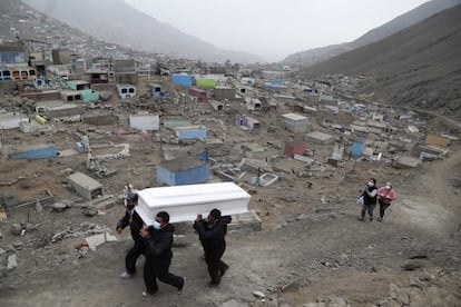 Los trabajadores del cementerio Mártires 19 de Julio trasladan un ataúd, a las afueras de Lima