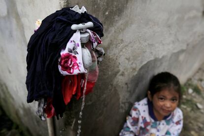 Una niña mira a cámara al lado de ropas lavadas frente al polideportivo de Santa Rosa de Copán, el 13 de octubre de 2018.
 
