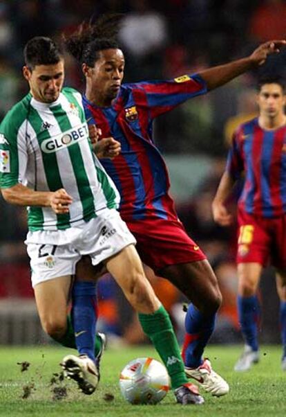 Melli disputa el balón con Ronaldinho en una jugada del partido. El equipo andaluz dio la vuelta al marcador con dos tantos de Dani, pero no sirvieron para poner en peligro la victoria azulgrana en el primer torneo de la temporada.