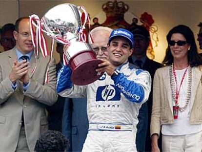 Juan Pablo Montoya levanta su trofeo de ganador ante la familia principesca de Mónaco: Alberto, Raniero y Carolina.