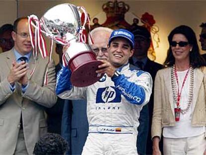 Juan Pablo Montoya levanta su trofeo de ganador ante la familia principesca de Mónaco: Alberto, Raniero y Carolina.