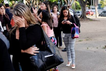 Una mujer utiliza su teléfono móvil después del sismo, en un calle de Caracas.