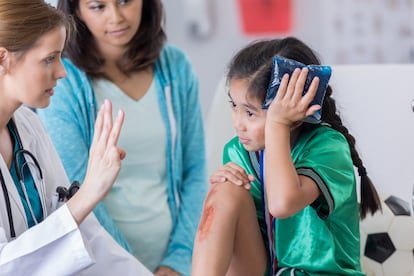 Una niña con golpe en la cabeza en una consulta médica. Las contusiones en esta zona son un motivo frecuente de consulta en los servicios de urgencia de los hospitales.