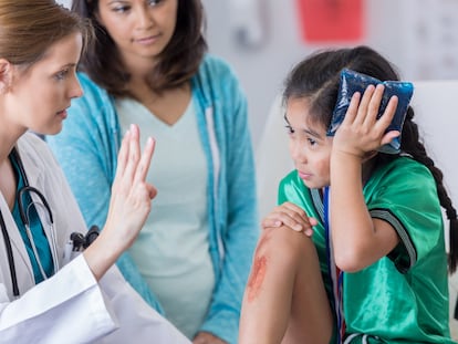 Una niña con golpe en la cabeza en una consulta médica. Las contusiones en esta zona son un motivo frecuente de consulta en los servicios de urgencia de los hospitales.