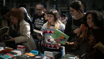 23/04/19 Una chica mira libros junto a una rosa en una de las paradas de libros de la Rambla.
 Diada de Sant Jordi, dia del Libro y la Rosa. Barcelona, 23 de abril de 2019 [ALBERT GARCIA] 
 