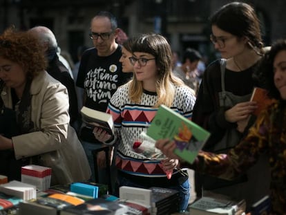 23/04/19 Una chica mira libros junto a una rosa en una de las paradas de libros de la Rambla.
 Diada de Sant Jordi, dia del Libro y la Rosa. Barcelona, 23 de abril de 2019 [ALBERT GARCIA] 
 
