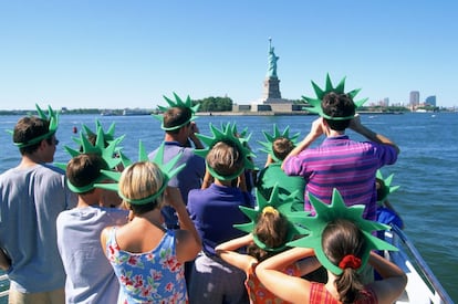 Un grupo de turistas toma fotografías a la estatua de la Libertad, en Nueva York.