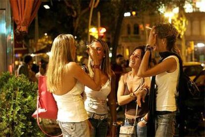 Un grupo de jóvenes fuma en una calle de Barcelona antes de entrar a una sala de fiestas.