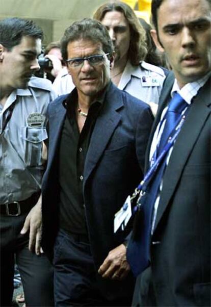 Fabio Capello, con personal de seguridad en el aeropuerto de Barajas.