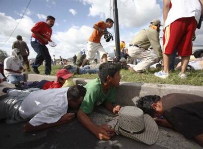 Seguidores de Zelaya se protegen del lanzamiento de gases lacrimógenos en el aeropuerto.