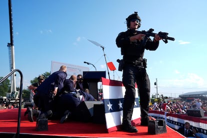 Republican presidential candidate former President Donald Trump is covered by U.S. Secret Service agents.