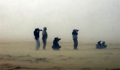 Varios fotógrafos de prensa y <b><i>marines</b></i> estadounidenses, durante una tormenta de arena en el desierto de Kuwait.