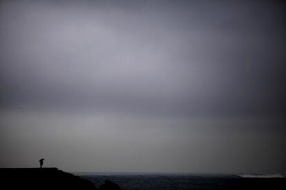 Una persona observa el mar desde la Playa de Riazor, en A Coruña, en una jornada marcada por la entrada de un frente poco activo que dejará lluvias generalizadas en toda la comunidad gallega y una bajada moderada de las temperaturas, según informa Meteogalicia.