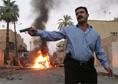 Un policía iraquí, ante un camión en llamas destruido por un ataque con proyectiles de mortero, ayer en Bagdad.