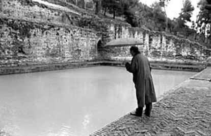 Un hombre observa uno de los albercones de la Alhambra.