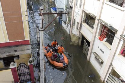 Un equipo de rescate evacúa a los residentes de una calle inundada de Hyderabad (India).