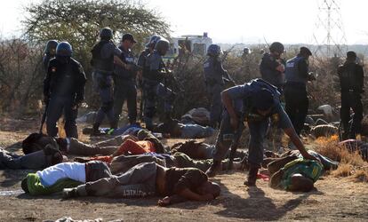 La policía inspecciona los cuerpos de los mineros abatidos durante la protesta.