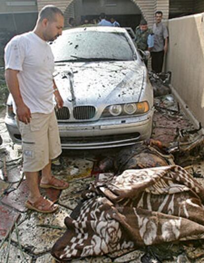 Un iraquí, ante una de las víctimas mortales del coche bomba de ayer en Bagdad.